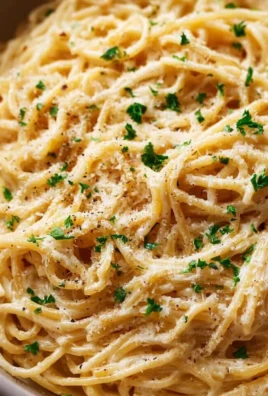 Bowl of cheesy garlic parmesan spaghetti garnished with parsley.