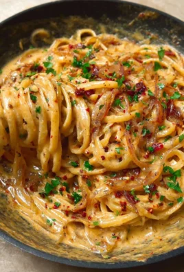 Plate of creamy caramelized onion pasta topped with herbs