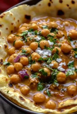 Bowl of creamy coconut chickpea curry garnished with fresh herbs and spices