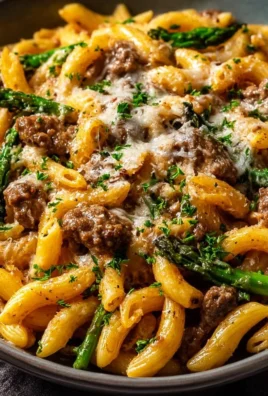 Creamy high protein beef pasta dish garnished with herbs and grated cheese