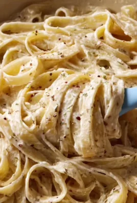 Plate of creamy Fettuccine Alfredo garnished with parsley and parmesan cheese