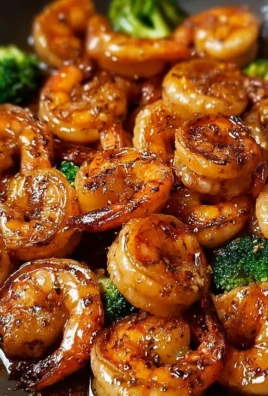 High-protein honey garlic shrimp served on a plate with vegetables.