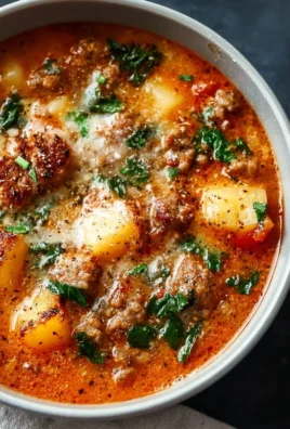 Bowl of flavorful Italian Sausage Soup garnished with fresh herbs.