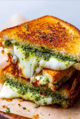 Delicious pesto grilled cheese sandwich with melted cheese and fresh basil