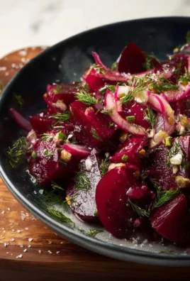Colorful pickled beet salad garnished with fresh herbs and feta cheese.