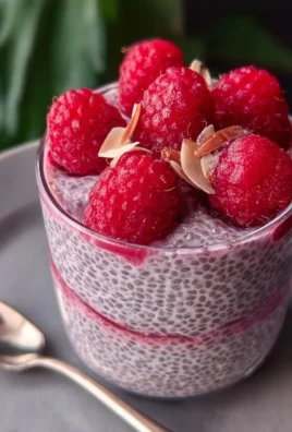 Delicious Raspberry Chia Pudding in a clear glass bowl with fresh raspberries