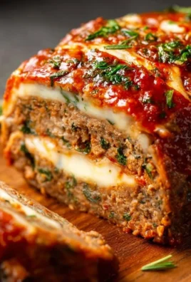 Delicious stuffed Italian meatloaf served with fresh herbs and tomato sauce