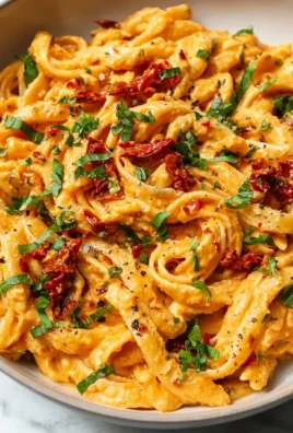 Vegan creamy sun dried tomato pasta served in a bowl with fresh herbs.