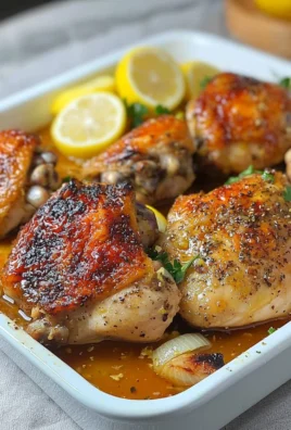 Baked Lemon Garlic Chicken garnished with fresh herbs on a white plate