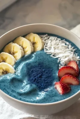 Delicious blue smoothie bowl topped with fruits and nuts