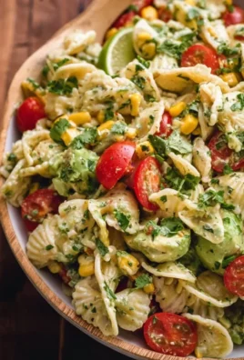Bowl of cilantro lime pasta salad with vibrant vegetables and fresh herbs