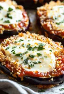 Crispy baked eggplant parmesan served on a plate with herbs and cheese