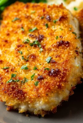 Parmesan Crusted Chicken garnished with herbs on a plate
