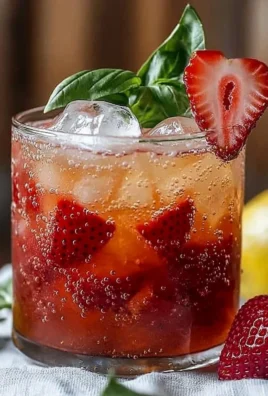 Refreshing Strawberry Basil Smash Cocktail served in a clear glass with fresh ingredients.