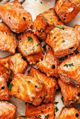 Delicious air fryer salmon bites served on a plate with garnishes.