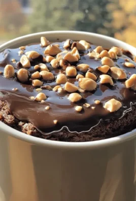 Delicious chocolate peanut butter mug cake in a white mug on a table.