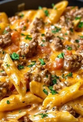 Creamy beef pasta dish served in a bowl with garnishes.