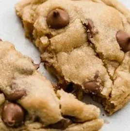Delicious Crumbl chocolate chip cookies stacked on a plate