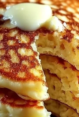 Flourless cottage cheese pancakes on a plate with fresh fruit and syrup