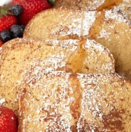 Deliciously golden French toast topped with fresh fruits and syrup.