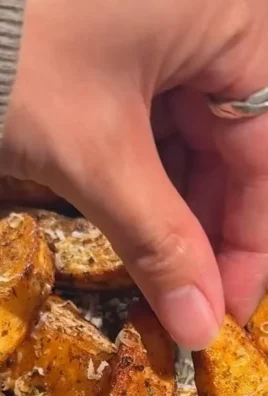 Plate of crispy air fryer potato wedges garnished with herbs