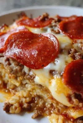 Delicious low carb pizza casserole dish ready to serve, topped with cheese and pepperoni.