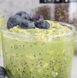 Bowl of matcha overnight oats topped with fresh fruit and nuts.