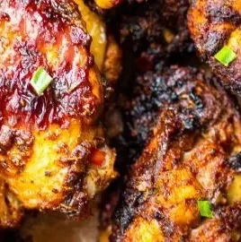 Plate of spicy air fryer chicken wings garnished with fresh herbs