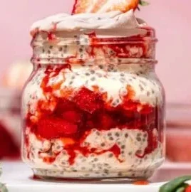 A bowl of Strawberries & Cream Overnight Oats topped with fresh strawberries.