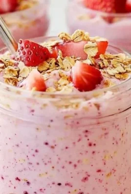 Bowl of strawberry cheesecake overnight oats with fresh strawberries on top.