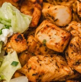 Air Fryer Greek Chicken garnished with herbs and lemon
