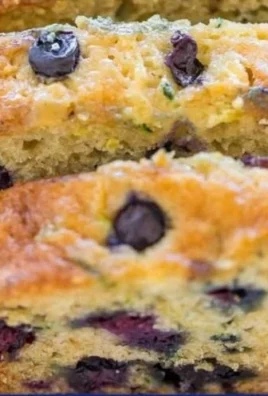 Freshly baked blueberry zucchini bread with blueberries and zucchini slices