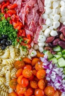 Colorful bowl of Italian pasta salad with fresh vegetables and herbs