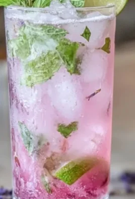 A refreshing lavender mojito mocktail in a glass with mint and lavender garnish.