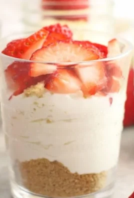 Delicious no-bake cheesecake cups topped with fresh berries and whipped cream.