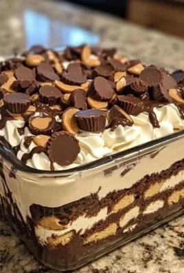 No-bake chocolate peanut butter dessert in a glass dish with chocolate drizzle