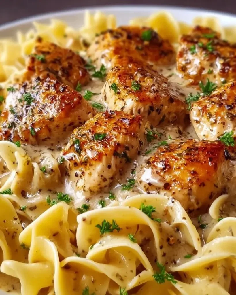 Creamy garlic butter chicken served with egg noodles in a skillet