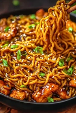 Plate of sticky garlic chicken noodles garnished with herbs and spices